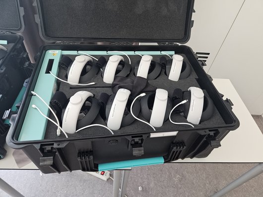 Geöffneter Transportkoffer mit acht Meta-Quest-Headsets in Schaumstoffeinsätzen.